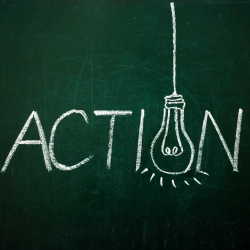 Mot "Action" écrit à la craie sur un tableau noir avec une ampoule dessinée illustrant les actions RSE inspirantes