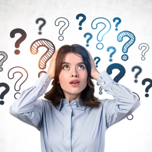 Femme d'affaires perplexe entourée de points d'interrogation illustrant les questions sur le développement durable en entreprise