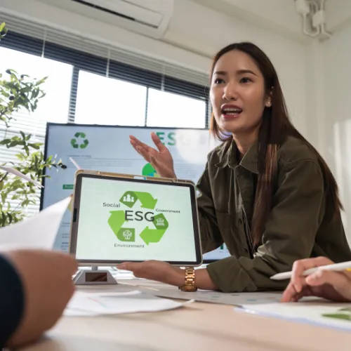 Consultante RSE présentant une tablette avec le logo ESG (Social, Gouvernance, Environnement) lors d'une évaluation RSE en entreprise