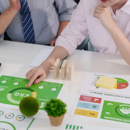 Équipe de professionnels analysant des rapports RSE, ESG et d'empreinte carbone avec des cubes en bois sur une table