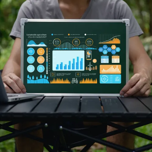 Personne tenant un tableau de bord numérique RSE avec des indicateurs de durabilité et d'agriculture durable dans un environnement naturel