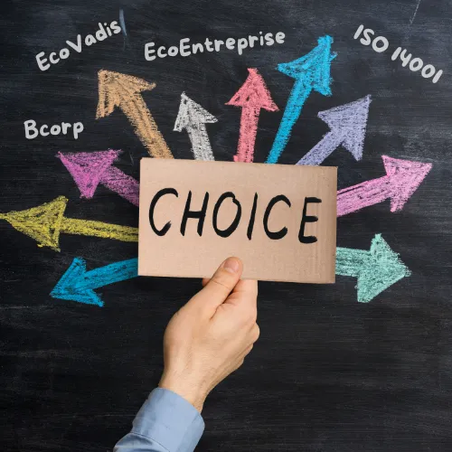 Main tenant une pancarte "Choice" sur tableau noir avec des flèches colorées pointant vers EcoVadis, B Corp, EcoEntreprise et ISO 14001